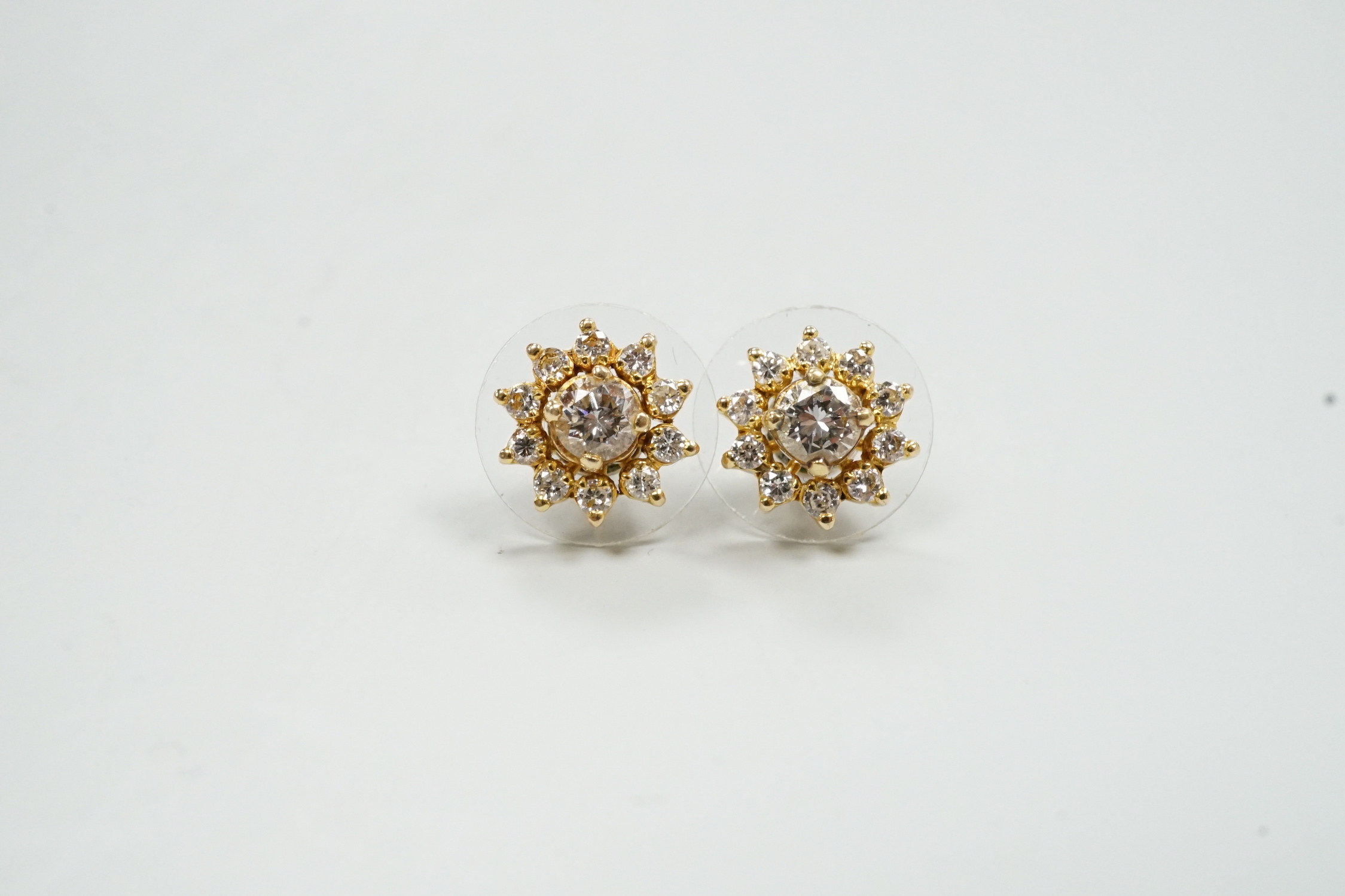 A modern pair of yellow metal and diamond cluster set flower head ear studs, with detachable collars